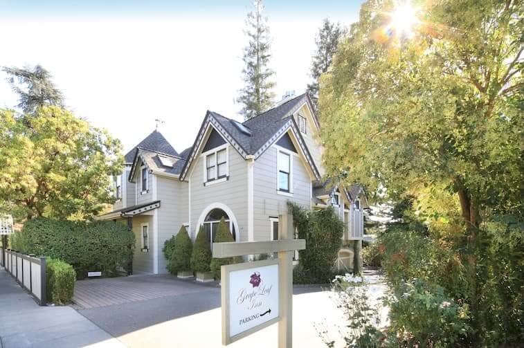 A charming two-story house with a gabled roof, nestled among lush greenery and a well-manicured garden in Healdsburg, California.