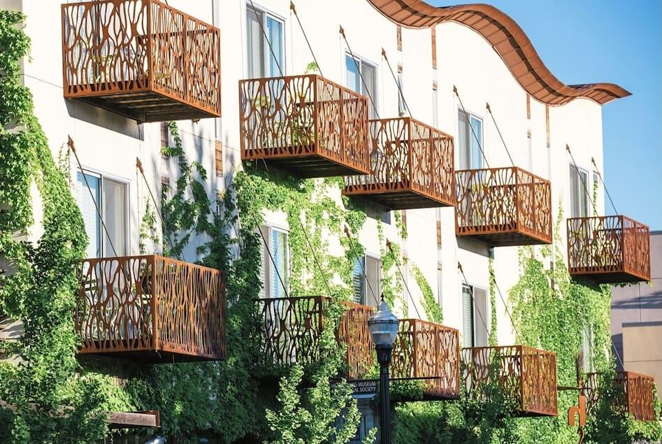 A modern building with unique, nature-inspired balconies covered in lush green ivy in Healdsburg, California.
