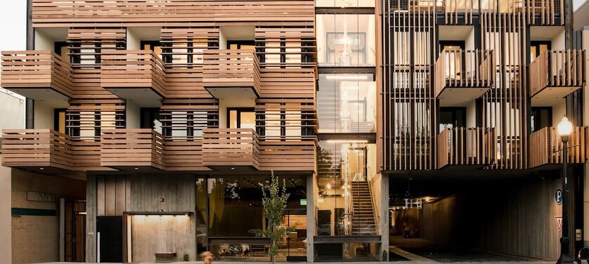 A modern multi-story building with a unique wooden facade featuring vertical and horizontal slats, creating a visually striking architectural design in Healdsburg, California.