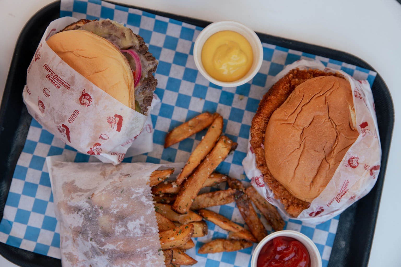 Iggy’s Organic Burger A tray holds three burgers wrapped in paper, a side of fries, and condiment cups in Healdsburg, California.