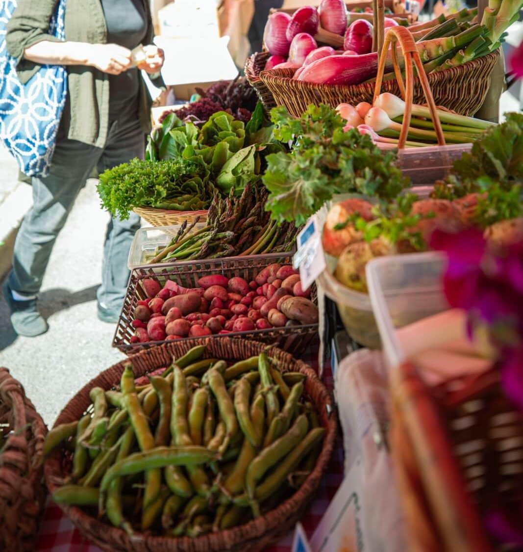 Healdsburg Farmers' Market A vibrant farmer's market display features fresh produce including leafy greens, beans, potatoes, and colorful vegetables in Healdsburg, California.