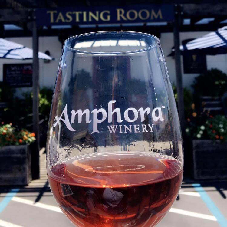 A glass of rosé wine from Amphora Winery sits in front of the tasting room entrance in Healdsburg, California.