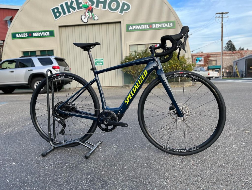 A sleek Specialized road bike with yellow accents is parked outside a bike shop in Healdsburg, California.