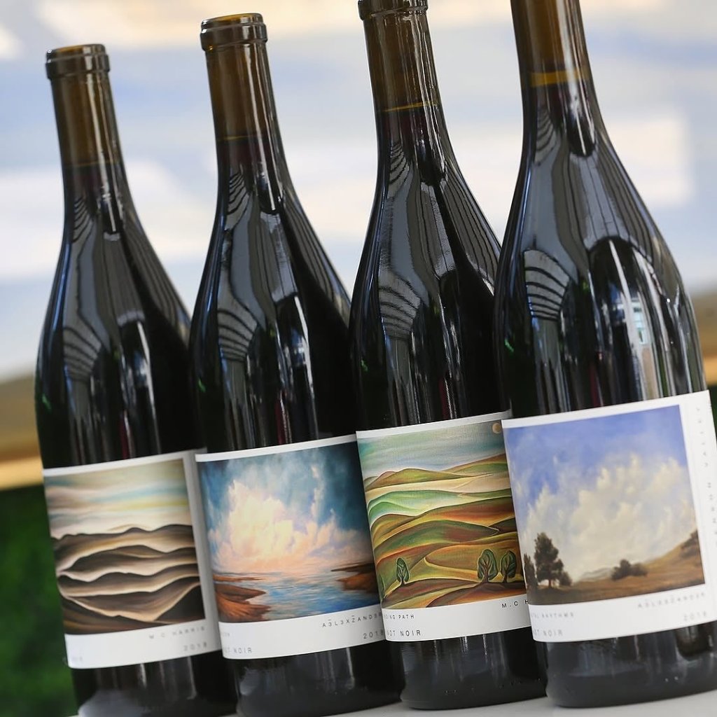 Four bottles of wine with colorful landscape labels stand side by side in Healdsburg, California.