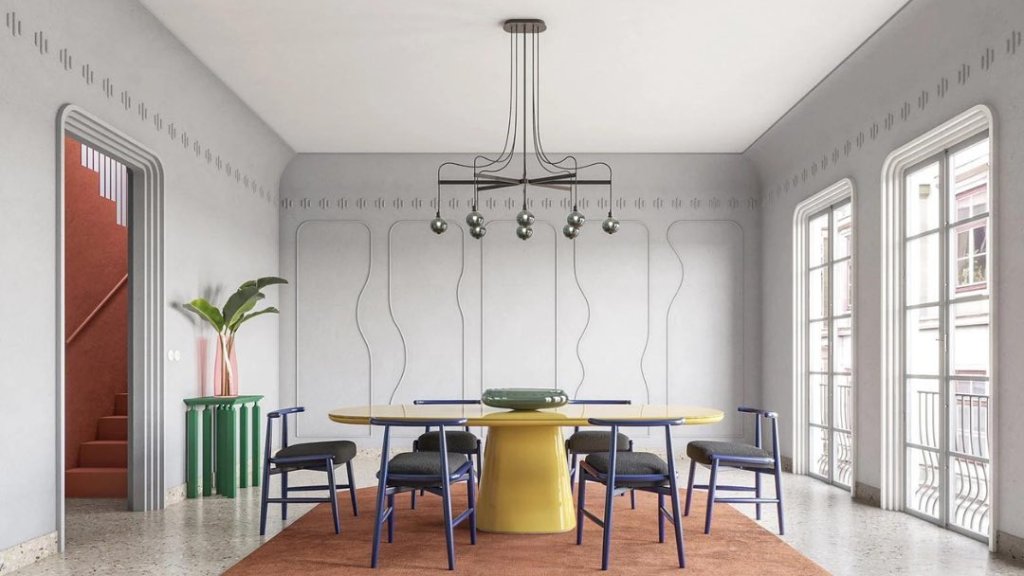 A modern dining room with a yellow table, blue chairs, and a geometric light fixture in Healdsburg, California.