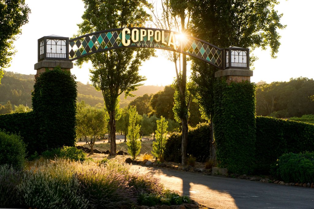 A stone archway covered in green vines welcomes visitors to Coppoia Winery in Healdsburg, California.