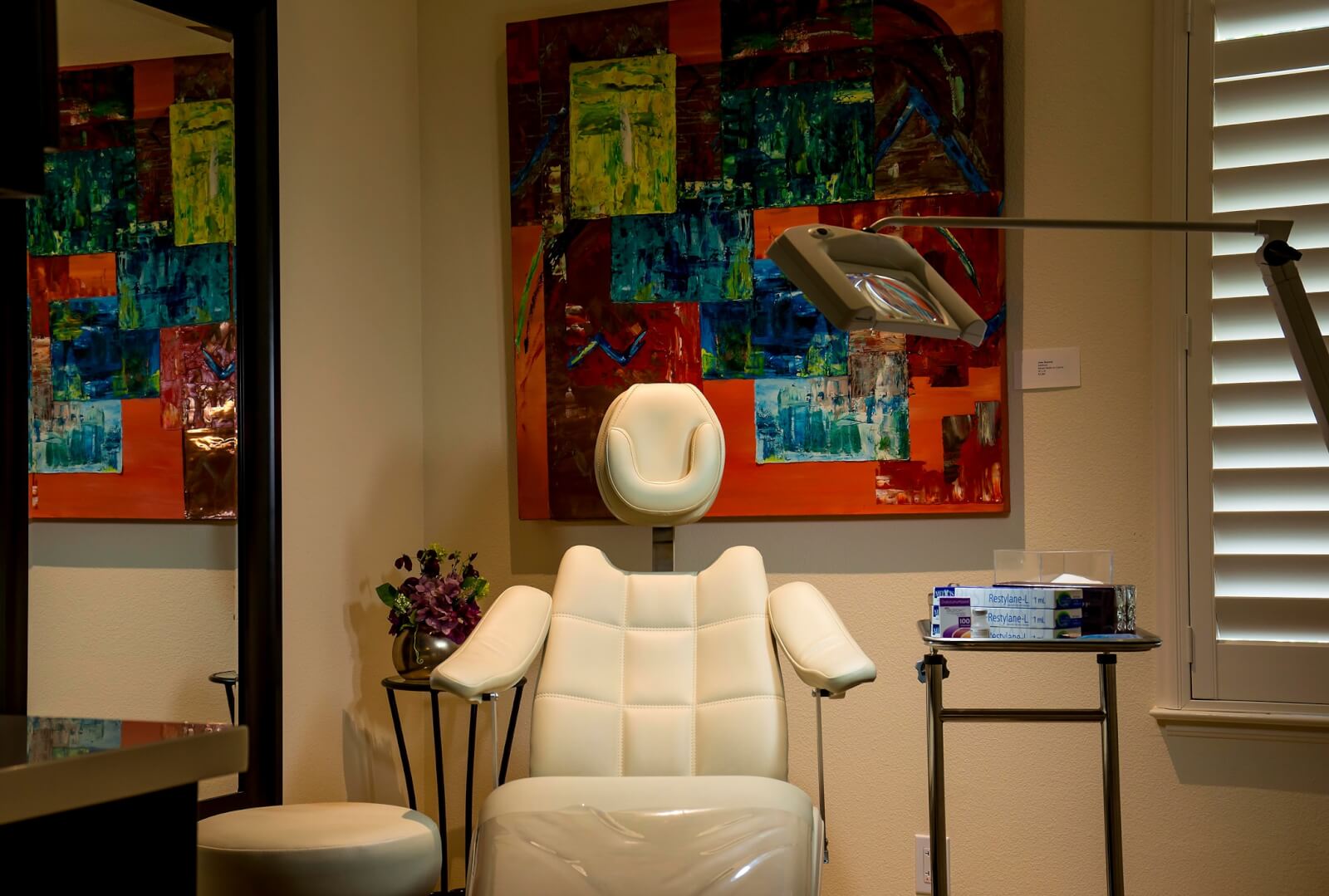 Artemedica A modern dental office features a white leather chair, a colorful abstract painting, and a medical tray in Healdsburg, California.