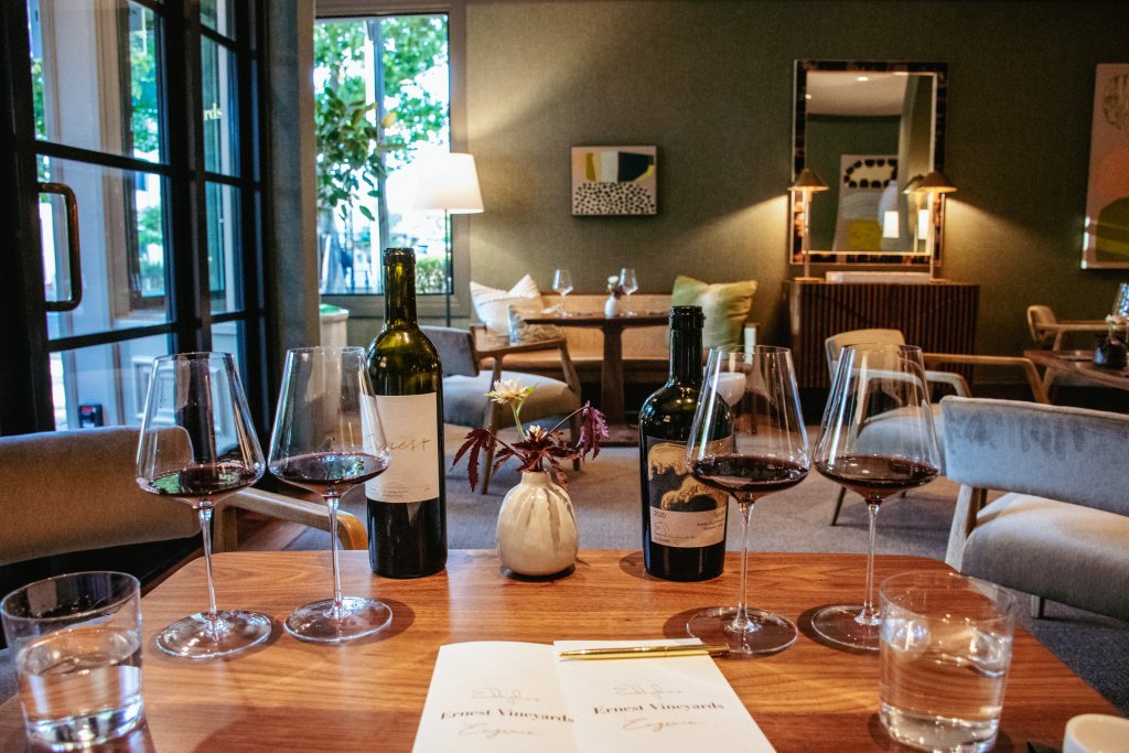 A cozy tasting room with wine bottles, glasses, and a menu on a wooden table in Healdsburg, California.
