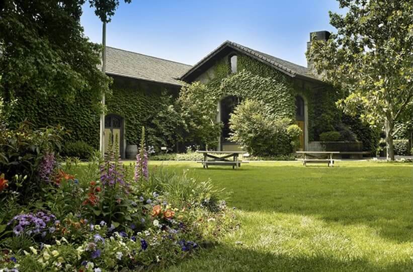 A charming country house surrounded by lush greenery and vibrant flower beds, with a peaceful garden and picnic area in Healdsburg, California.