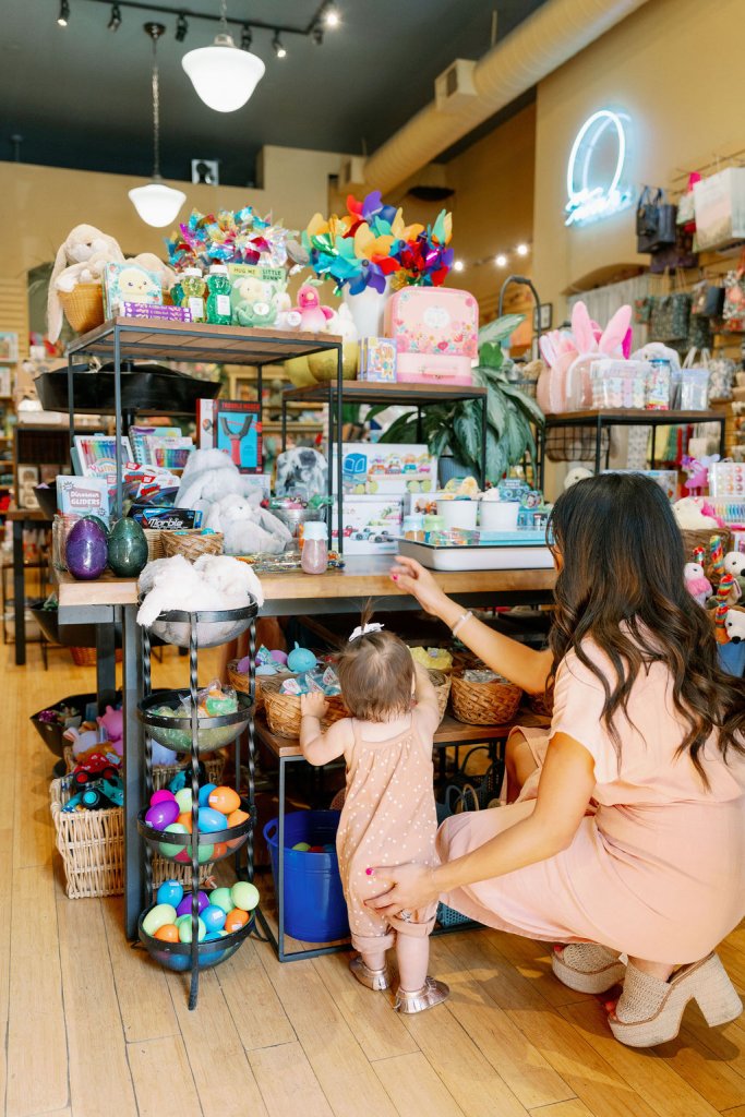 A mother and child explore colorful toys and Easter eggs in a gift shop in Healdsburg, California.