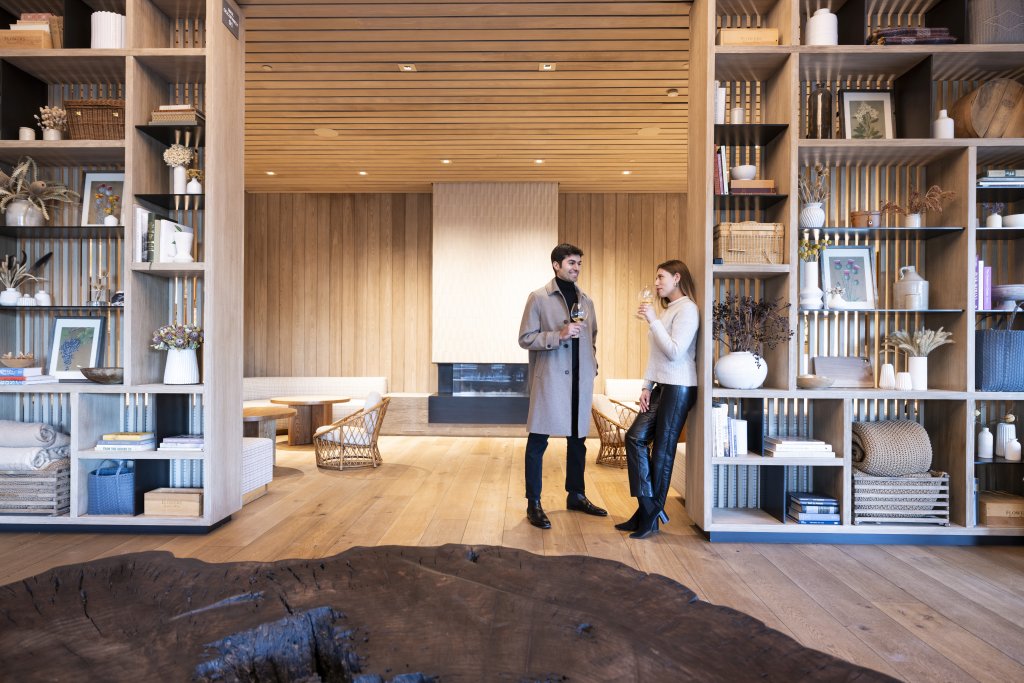 A couple enjoys wine in a modern, cozy living room with wooden accents and a fireplace in Healdsburg, California.