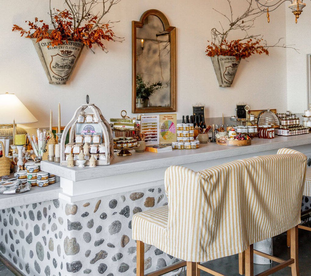 La Ruche A cozy, rustic-chic kitchen with a stone-tiled bar, striped bench, and autumnal decor in Healdsburg, California.
