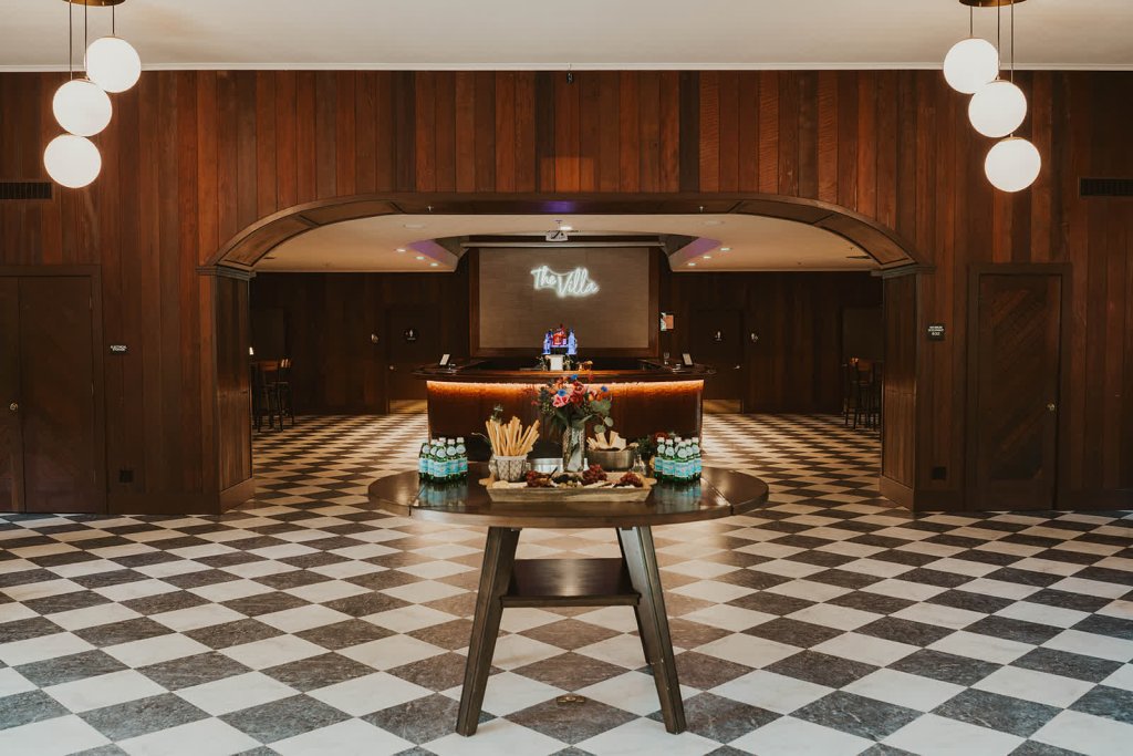 A stylish lobby with a checkered floor, wooden walls, and a round table with snacks in Healdsburg, California.