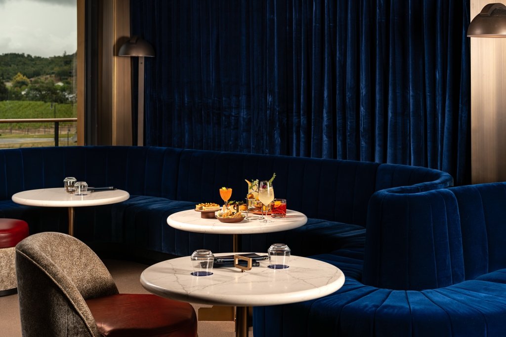 A stylish bar area with blue velvet seating, white marble tables, and colorful cocktails in Healdsburg, California.