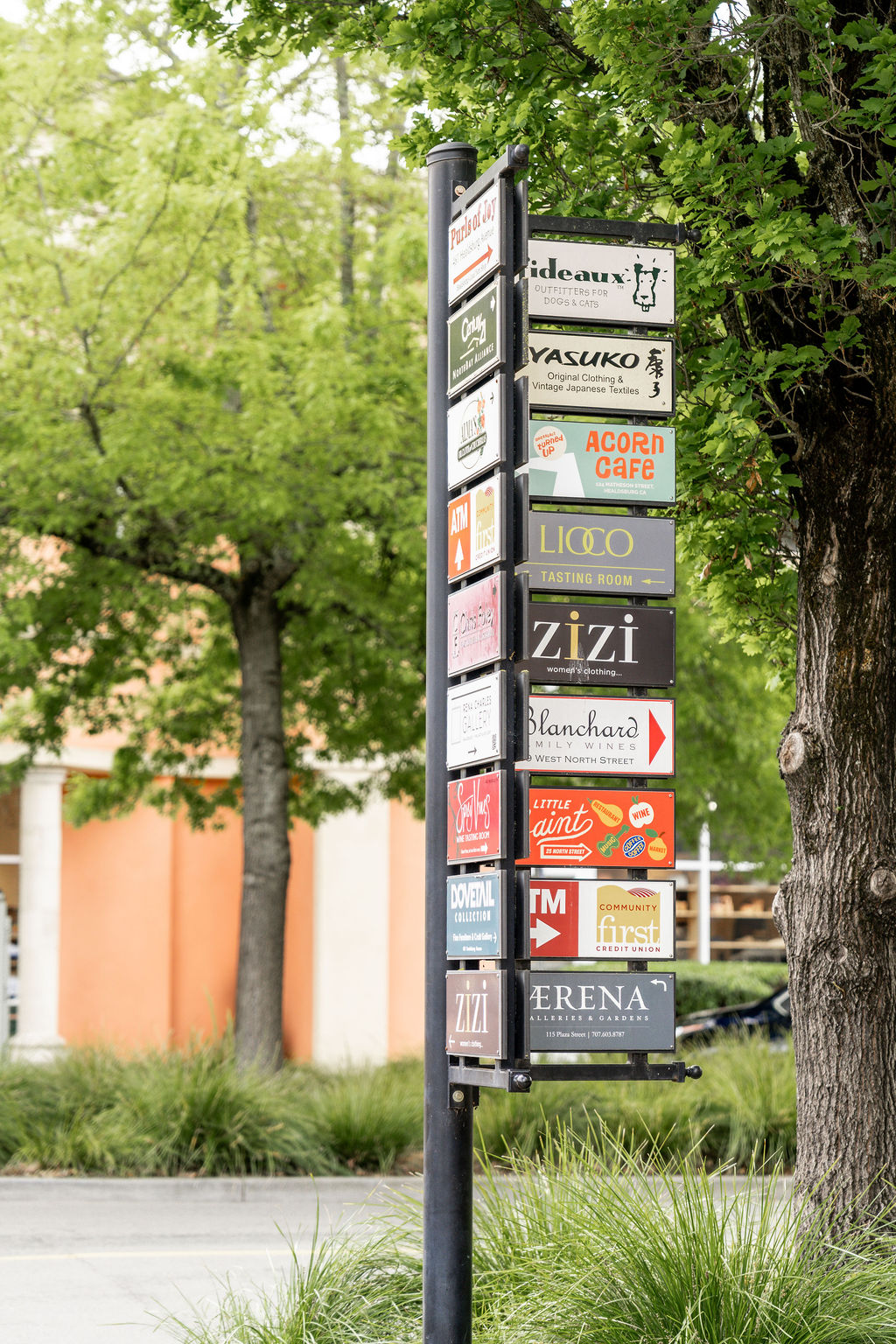 List Your Business A tall pole with multiple colorful signs advertising various businesses and services in Healdsburg, California.