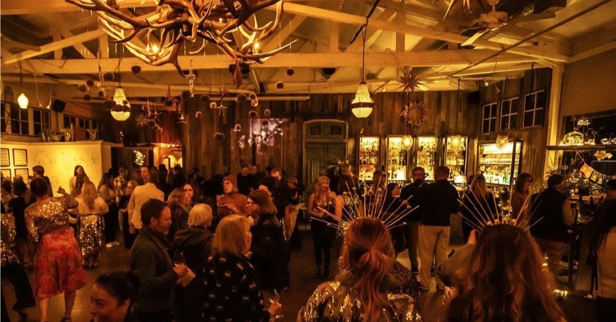 Crowded, dimly lit bar with antler chandeliers and festive decorations in Healdsburg, California.