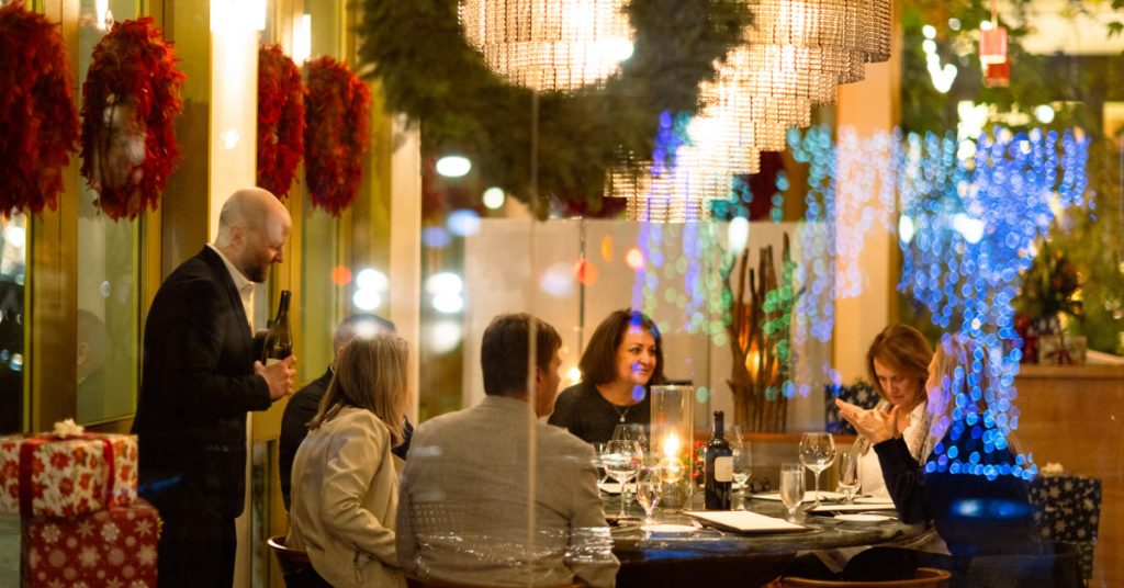 A festive group dinner with wine, candles, and holiday decorations in Healdsburg, California.