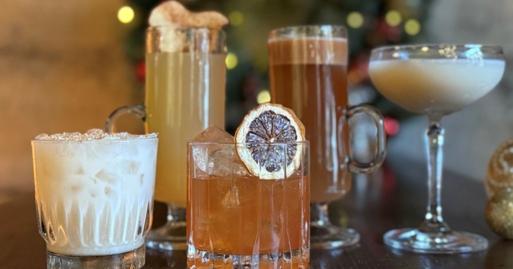 Four festive cocktails with seasonal garnishes on a wooden table in Healdsburg, California.