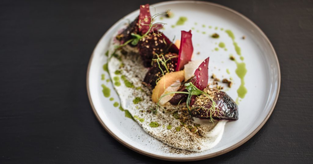 A beautifully plated dish featuring beets, citrus, and greens with a creamy sauce in Healdsburg, California.