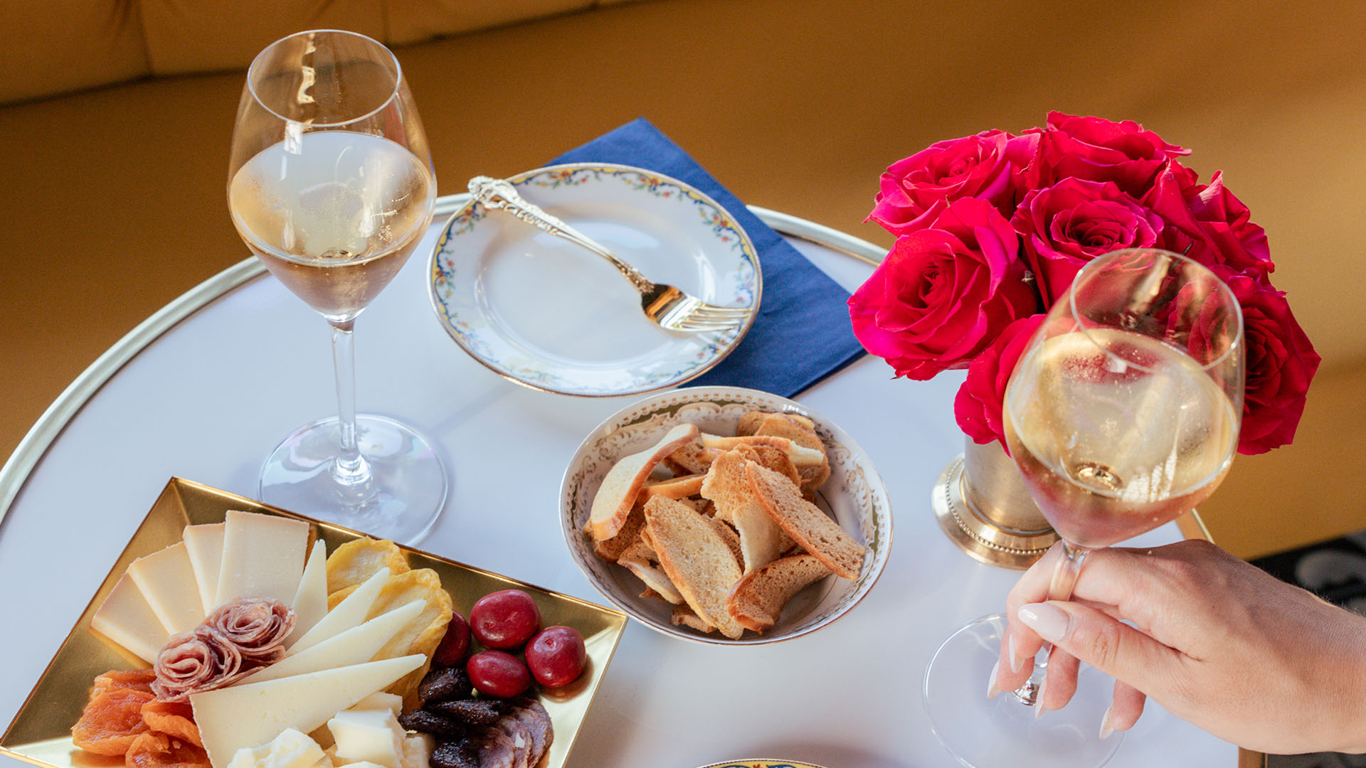 Food & Drink A table set with cheese, crackers, fruit, and two glasses of champagne with red roses in Healdsburg, California.