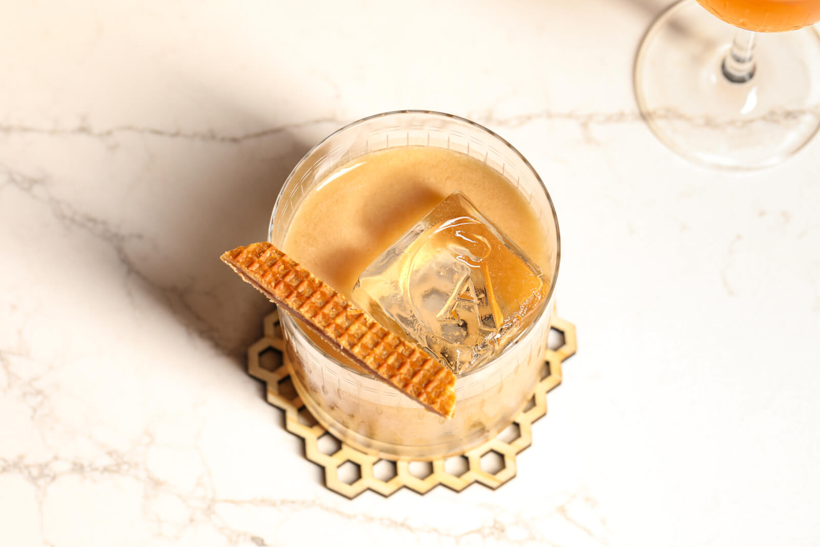 A glass of creamy, caramel-colored cocktail with ice and a waffle stick garnish in Healdsburg, California.
