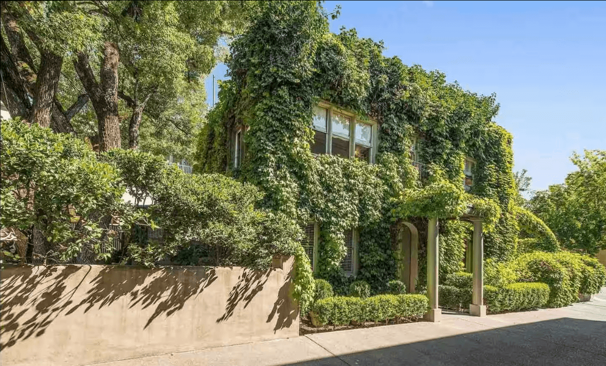 Ivy House Healdsburg A lush, ivy-covered house nestled among mature trees and manicured hedges in Healdsburg, California.