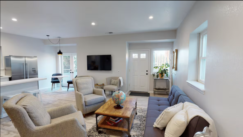 A modern living room with a blue sofa, gray armchairs, and a wooden coffee table in Healdsburg, California.