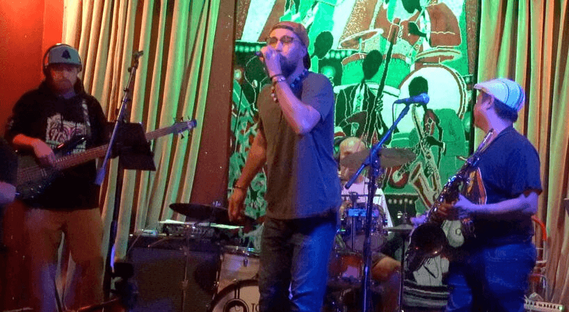 A lively band performs on stage with a vibrant mural backdrop in Healdsburg, California.