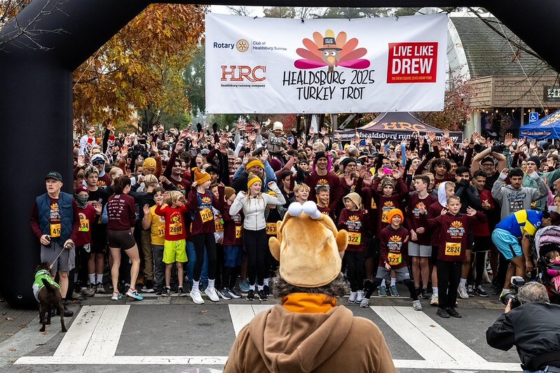 A large crowd of people gathered at the starting line of a turkey trot race in Healdsburg, California.